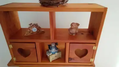 A BEAUTIFUL AND UNIQUE PINE STAINED SHELF WITH DECORATIVE HEART CUTOUT DOORS AND SHELVES TO DISPLAY...