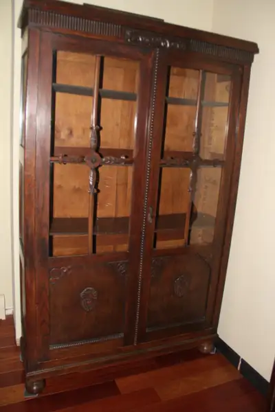 Very unique antique book case made of oak. Hand-carved oak trim all around including on glass doors....