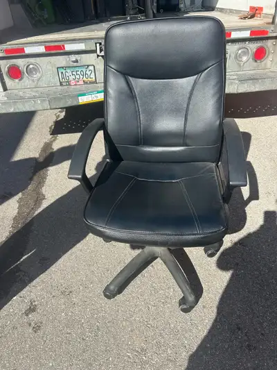 This is a used black leather swivel chair, perfect for an office or home workspace, featuring a comf...