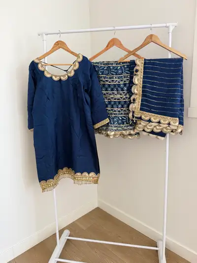 This beautiful blue kurti and Sharara set features intricate gold embroidery and scalloped trim. The...