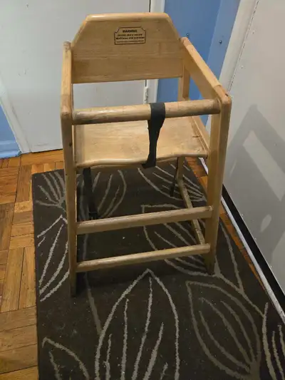 Wooden high chair by Winco. It has a safety strap and wooden tray bar. Made of solid wood. This chai...