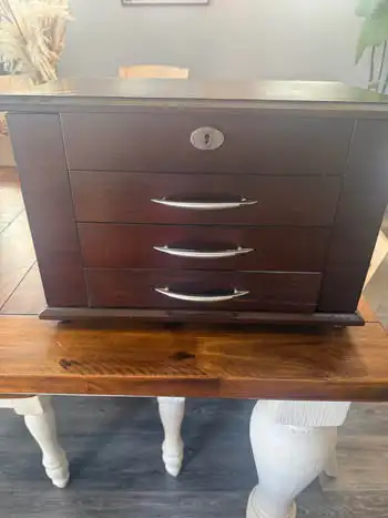 Dark wood jewelry box has a mahogany finish with silver-tone hardware. This storage chest features t...