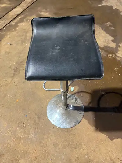 This used adjustable stool features a black seat and a chrome base, perfect for adding a touch of mo...