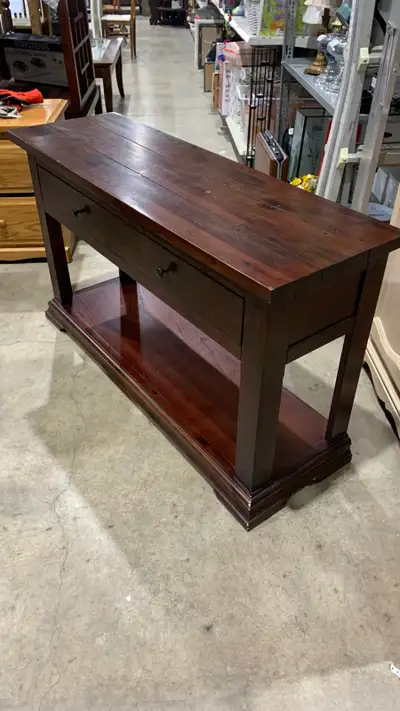 I am selling a dark wood console table, perfect for entryways or living rooms. This used table featu...