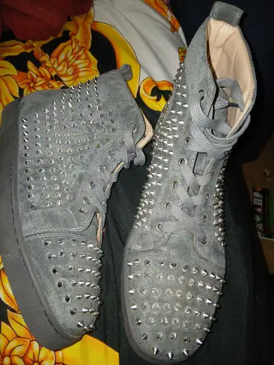 These are pre-owned grey Christian Louboutin high-top sneakers, embellished with silver spikes, offe...