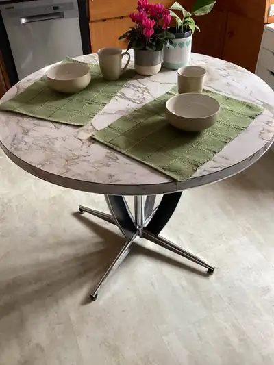 Vintage arborite kitchen table with black and chrome pedestal base. 37” diameter, 30” tall. Good siz...