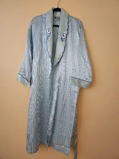 Peignoir vintage à rayures sur fond turquoise. Il est doté d’une ceinture à nouer amovible réglable...