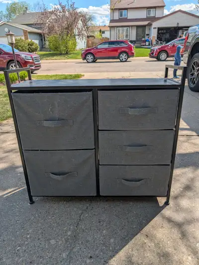 A shelving unit with steel frame and solid wood top, with five fabric drawers of varying size. Good...