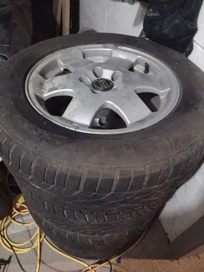 Offering a set of Volvo rims with winter tires, sized at 215/65 R16, perfect for safe winter driving...