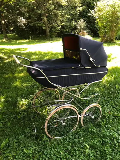 Italian made, vintage baby pram, featuring a classic navy blue exterior with a red interior. It is c...