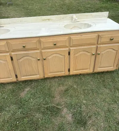 A double sink vanity top. Features two sinks with faucets. Made of a light-coloured material. Perfec...