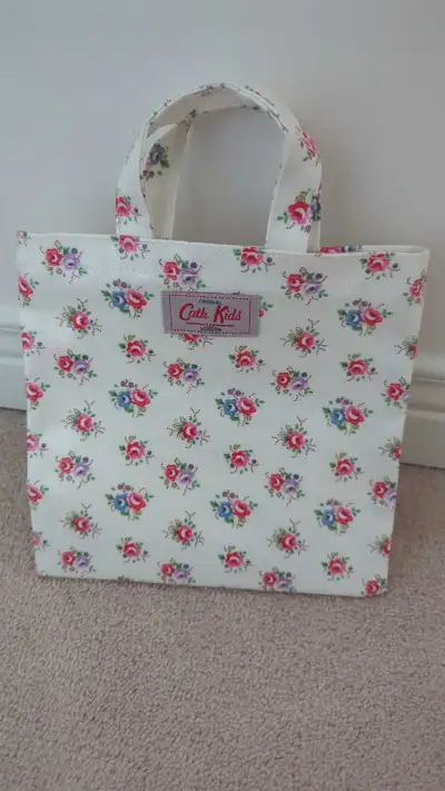 This charming Cath Kids floral tote is perfect for carrying your essentials with a touch of vintage...