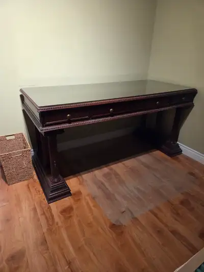 Bombay computer desk with glass top 65"Wx28.5"Dx31"H, pedestals are removable. Mahogany in color.