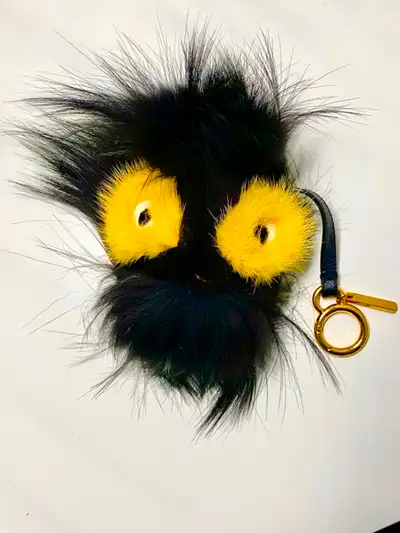 Fendi bag charm in soft black fur with contrasting yellow eyes and gold tone hardware. Fun accessory...