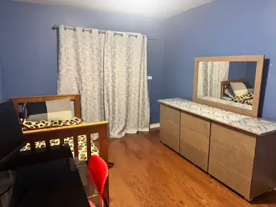 These rooms are move-in ready, with some furniture included. The room features a dresser and bed fra...