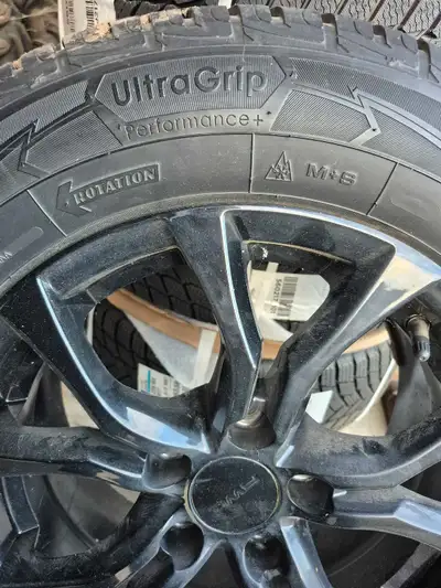 Goodyear UltraGrip Performance+ tires, size 215/65R16, are mounted on sleek black 16" aluminum rims,...