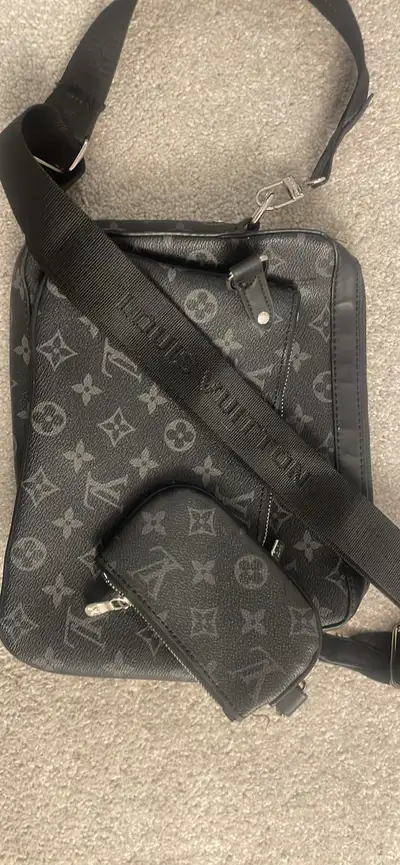 Elevate your style with this sleek, used Louis Vuitton messenger bag in black and grey monogram ecli...