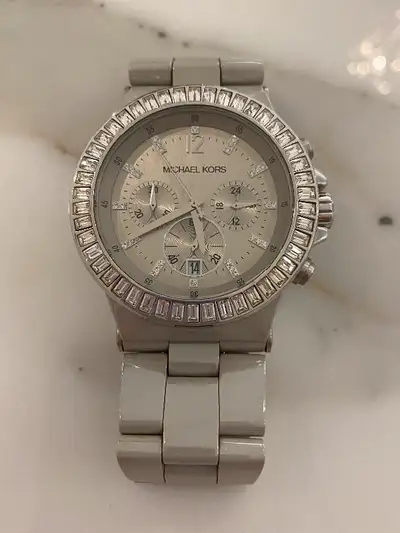 Montre de marque Michael Kors en céramique de couleur gris taupe avec cadran en baguette de cristaux...