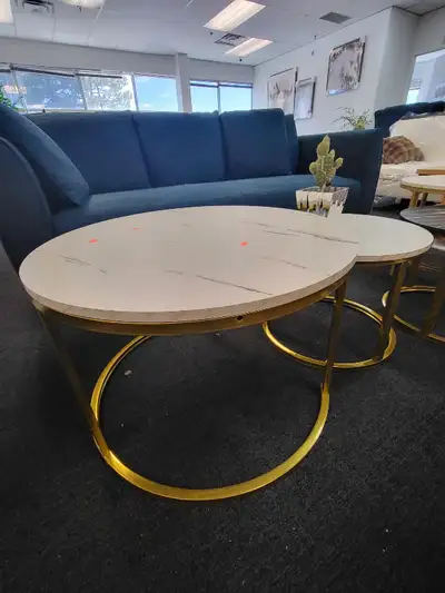Add a touch of modern elegance to your living space with this used nesting coffee table set, featuri...