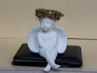 Ceramic Cherub with Floral Headband Sits on Shelf