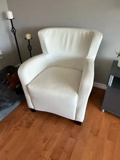 Ce petit fauteuil blanc crème offre un confort douillet avec une touche d'élégance simple, parfait p...