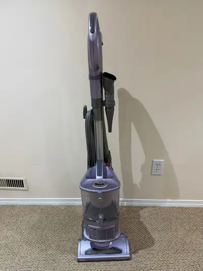 This is a purple Shark Navigator vacuum cleaner. It's a lift-away model with a powerful suction. Gre...