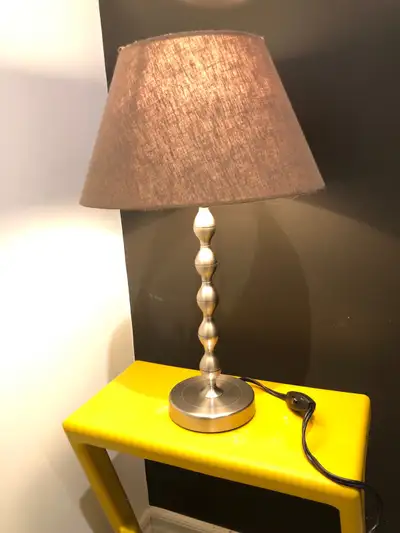 Like new, LED light bulb included. Stainless steel body, linen shade. Base width: 5” Height: 17.5” L...