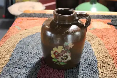 Hi. I have a vintage small stoneware jug/crock for sale. The jug has a dark brown glaze with a flora...