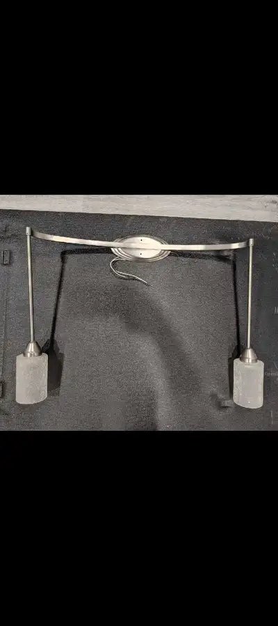 Brushed nickel track-style vanity light fixture with textured c, View more