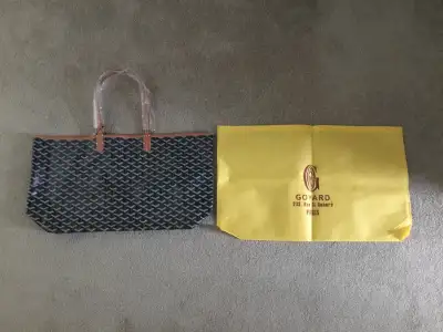 Goyard Tote Bag Color: Black with brown strap Measurements: 20.5 x 11.5 inches Condition: Brand new
