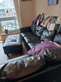 Faux leather sofa with storage table and accent pillows.