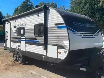 This pre-owned Pioneer RB215 travel trailer offers a spacious 25-foot layout perfect for your next f...
