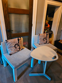 Two upholstered caster chairs with pillows + IKEA laptop table