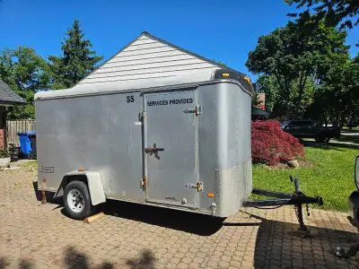 2005 Aluminum Haulmark Transport DLX enclosed single-axle trailer is silver with a wood-lined interi...
