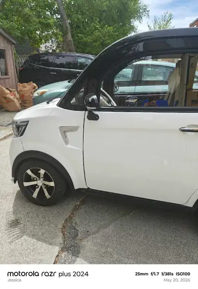 This enclosed electric scooter is nearly new, featuring a sleek white exterior with black accents. I...