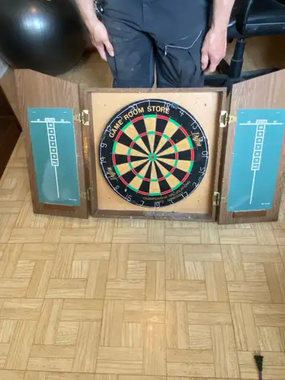 Dufferin dart board, perfect for game nights! This used dart board comes complete with its cabinet a...