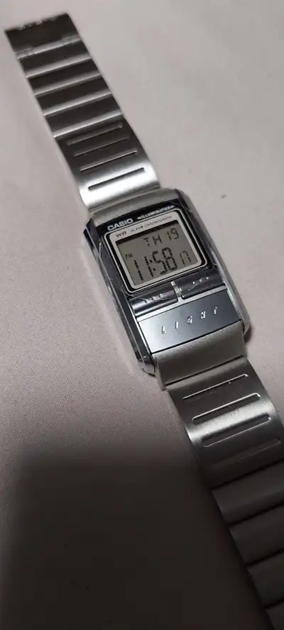 Own a piece of retro cool with this used Casio Illuminator digital watch. It has a sleek silver fini...