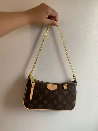Louis Vuitton Pochette. Its classic design and iconic monogram make it a versatile accessory for any...