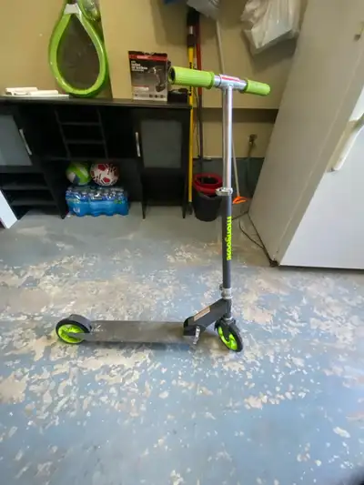 Children’s green and grey Mongoose scooter. Comes with an attached stand.