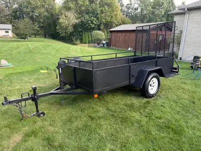 This sturdy black steel utility trailer features a rear ramp gate and a spare tire, it also has tied...
