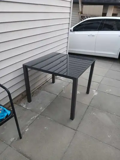 Selling and clean and modern outdoor patio table. Made of durable metal with a glass top. Comes with...