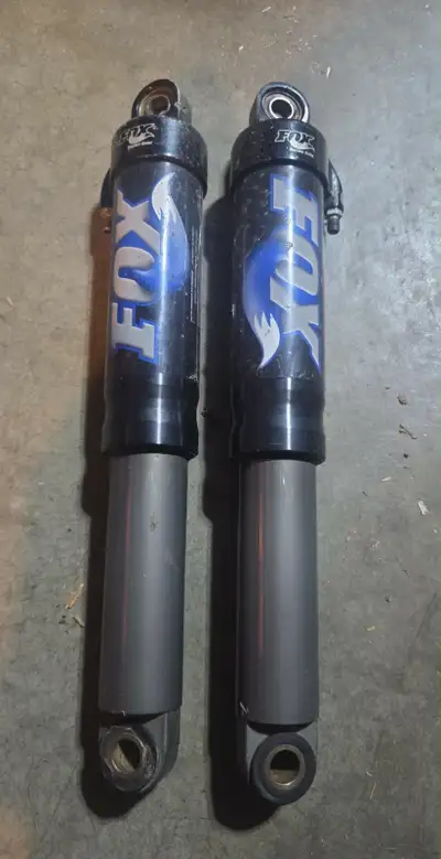 These are a pair of Fox Float shocks, known for their FOX Load Optimized Air Technology. These shock...