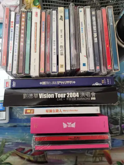 For sale is a diverse collection of used CDs and DVDs, featuring various artists and titles, includi...