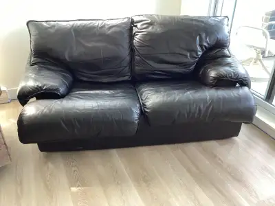 Voici une causeuse en cuir véritable noire qui offre à la fois confort et style. Bien qu'elle soit d...