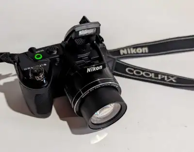 Nikon Coolpix L310 digital camera. Includes neck strap and lens cover. Bridge camera. Features 14.1...