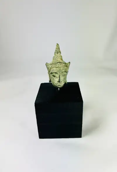 This small, beautifully crafted Buddha head is an exquisite example of Southeast Asian religious art...