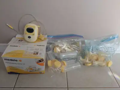 Medela Pump Kit with bottles, lids, bra pads, bags and straps.