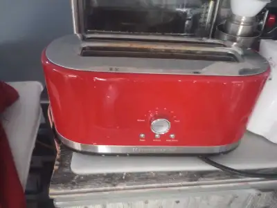 Voici un grille-pain KitchenAid rouge vif, parfait pour ajouter une touche de couleur à votre cuisin...