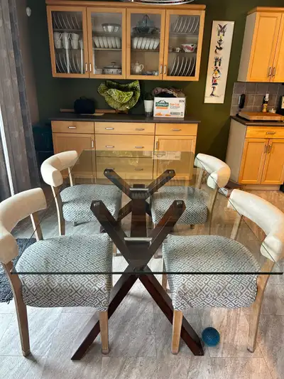 Stylish glass top kitchen table with wooden cross style legs. Seats 6 comfortably and measures 29.5'...