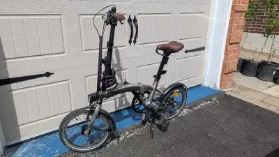 This B'Twin folding bike features a reliable 9-speed Shimano Sora drivetrain, perfect for urban comm...